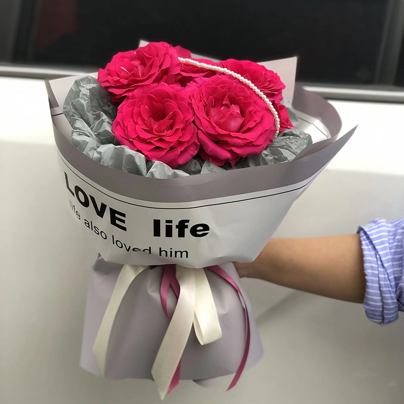 Glattes Geschenkpapier mit beschrifteten Blumen